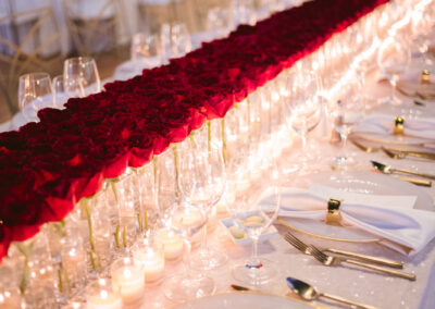wedding tablescape lined with red roses down center of banquet tables